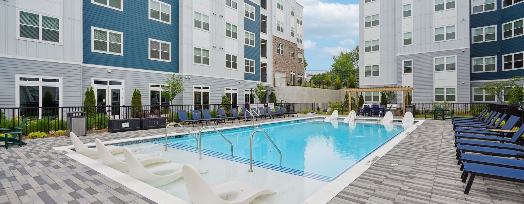 a courtyard with a swimming pool and lounge chairs