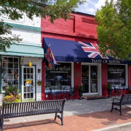 a group of shops in a plaza with a bench