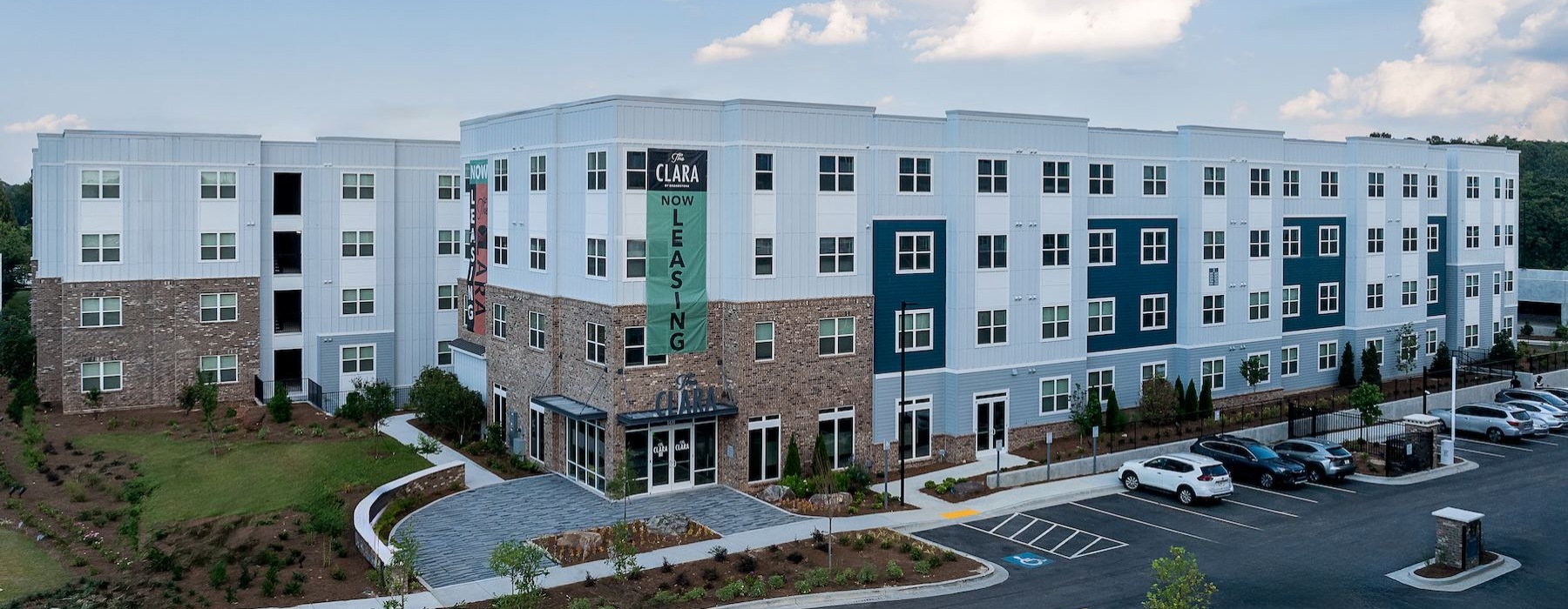 an apartment building with cars in a parking lot